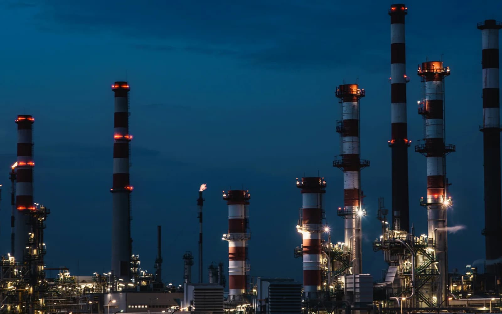 An illuminated industrial energy facility at dusk